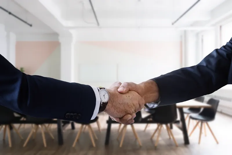 Aperto de mão selando uma contratação, representando o início de um vínculo CLT em período de experiência