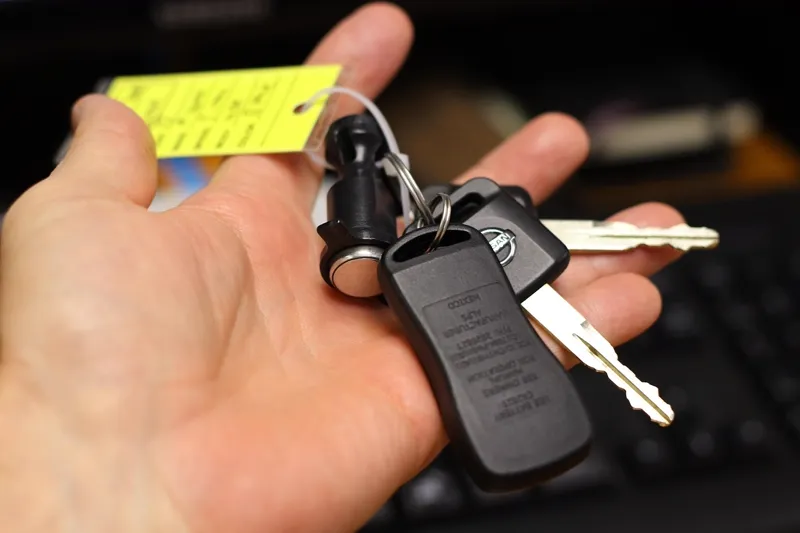 Chave de carro com etiqueta amarela na mão de uma pessoa